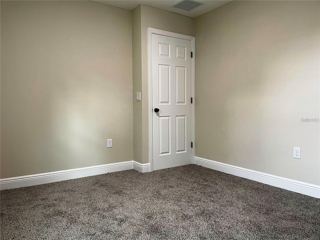 carpeted spare room featuring visible vents and baseboards