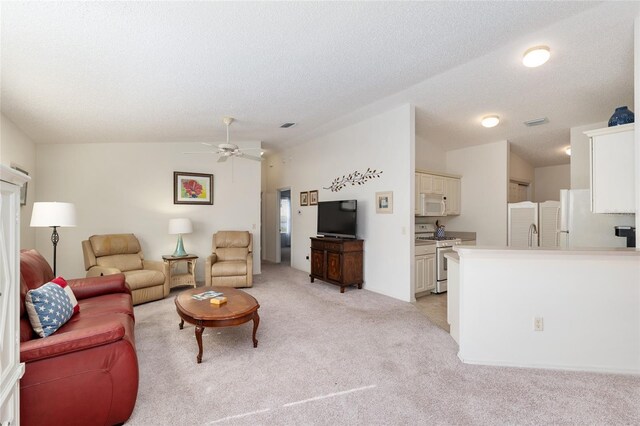 living area with visible vents, light carpet, ceiling fan, and vaulted ceiling