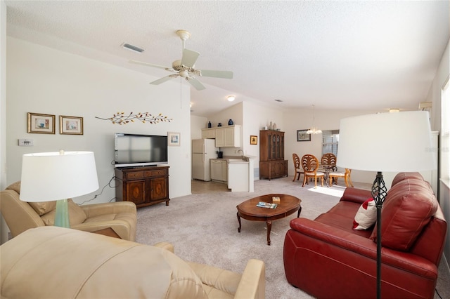 living area with a wealth of natural light, light carpet, ceiling fan, and vaulted ceiling