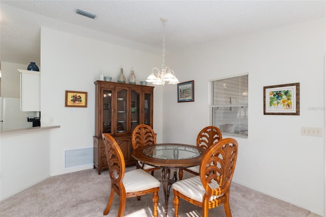 dining room with a chandelier, visible vents, and light colored carpet