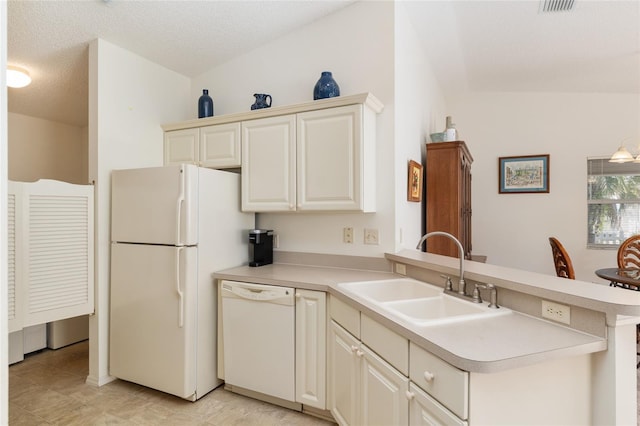 kitchen with light countertops, a sink, a peninsula, and white appliances