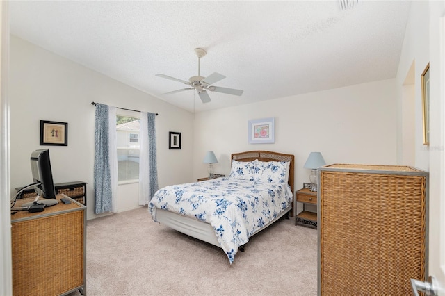 bedroom featuring a textured ceiling, a ceiling fan, and light carpet