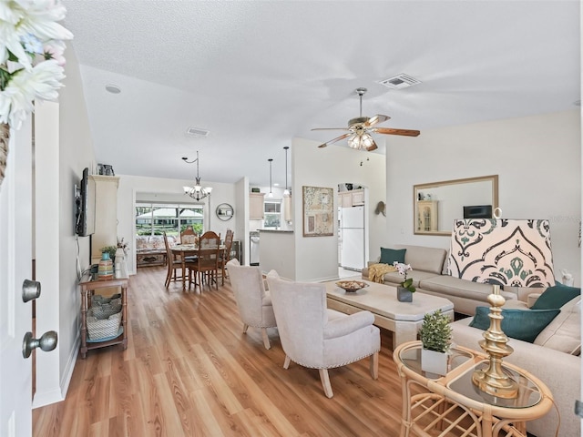 511 Chula Vista Ave, The Villages, FL 32159 - living area featuring vaulted ceiling, light wood-style flooring, visible vents, and ceiling fan with notable chandelier