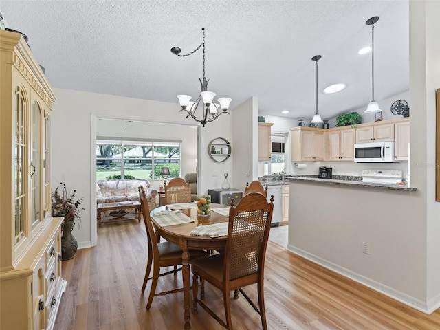 511 Chula Vista Ave, The Villages, FL 32159 - dining space featuring a chandelier, light wood-style floors, a textured ceiling, and baseboards