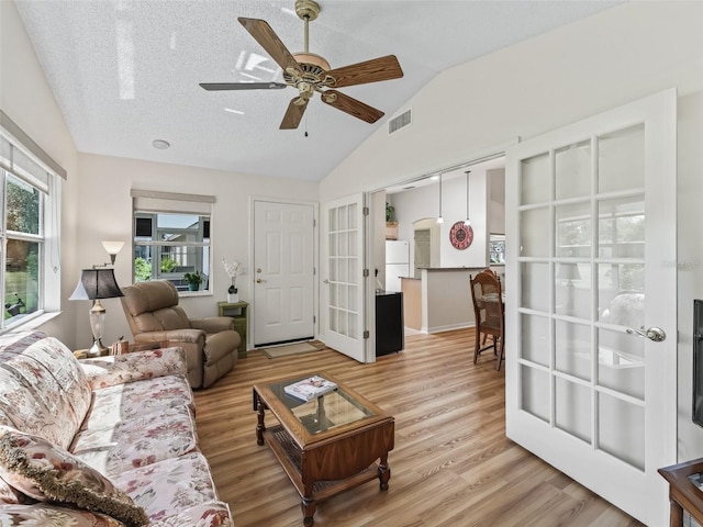 511 Chula Vista Ave, The Villages, FL 32159 - living room featuring light wood finished floors, french doors, vaulted ceiling, and visible vents