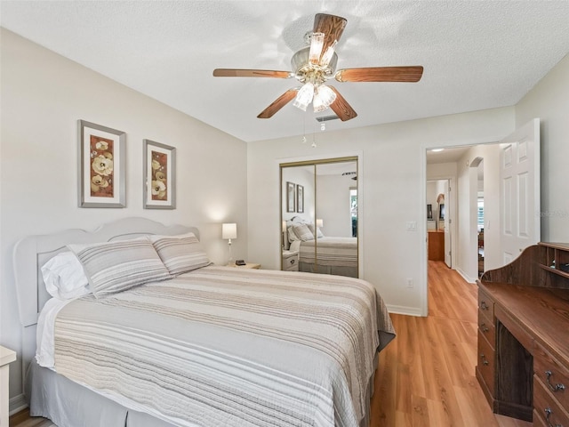 511 Chula Vista Ave, The Villages, FL 32159 - bedroom featuring a ceiling fan, a textured ceiling, a closet, light wood-style flooring, and baseboards