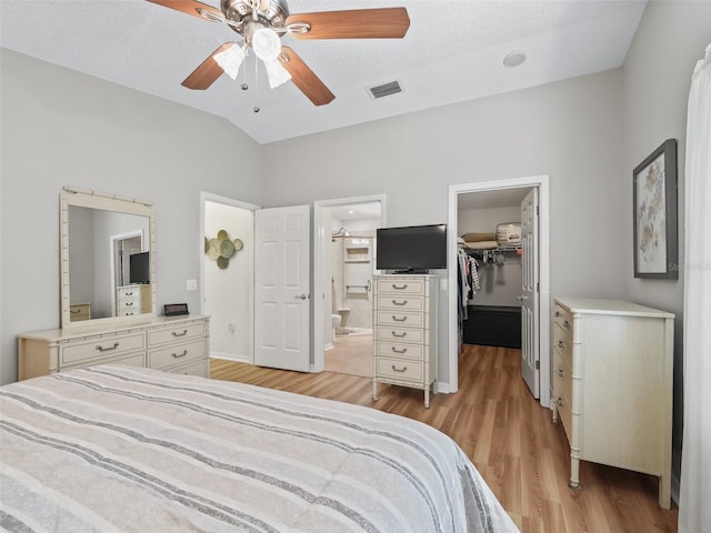 511 Chula Vista Ave, The Villages, FL 32159 - bedroom featuring visible vents, light wood-style floors, lofted ceiling, connected bathroom, and a walk in closet