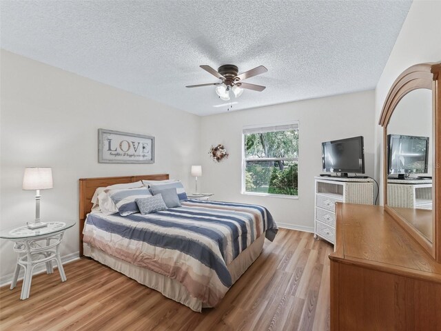 511 Chula Vista Ave, The Villages, FL 32159 - bedroom featuring baseboards, a ceiling fan, a textured ceiling, and light wood-style flooring