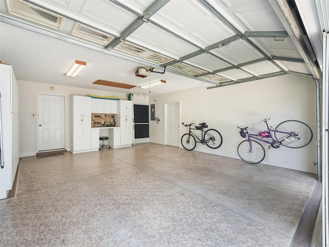 511 Chula Vista Ave, The Villages, FL 32159 - garage featuring a garage door opener, electric panel, and baseboards