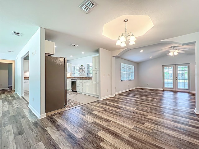 203 SE 30th Ave, Ocala, FL 34471 - unfurnished living room with wood finished floors, baseboards, a chandelier, a ceiling fan, and lofted ceiling