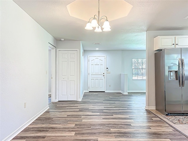 203 SE 30th Ave, Ocala, FL 34471 - unfurnished dining area featuring a chandelier, wood finished floors, baseboards, and a textured ceiling