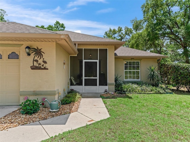 doorway to property featuring a garage, a shingled roof, a yard, and stucco siding