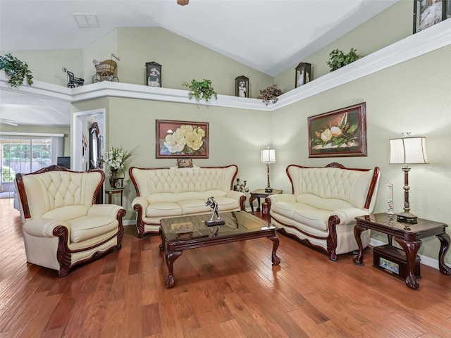living area with wood finished floors, visible vents, and high vaulted ceiling