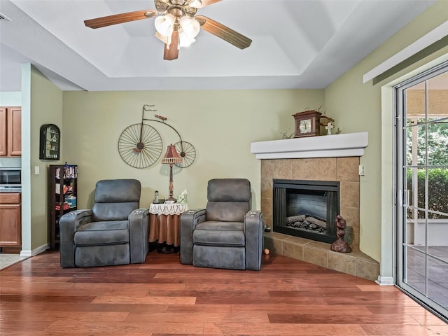 sitting room featuring a tray ceiling, wood finished floors, and ceiling fan