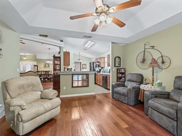 living area with lofted ceiling, visible vents, a ceiling fan, and hardwood / wood-style flooring