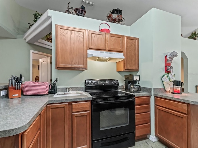 kitchen with brown cabinets, under cabinet range hood, black range with electric stovetop, light tile patterned flooring, and a peninsula