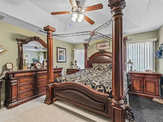bedroom with carpet floors, a ceiling fan, ornate columns, and multiple windows
