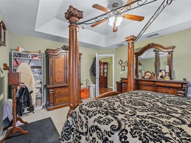 bedroom featuring decorative columns, visible vents, carpet, a ceiling fan, and a raised ceiling