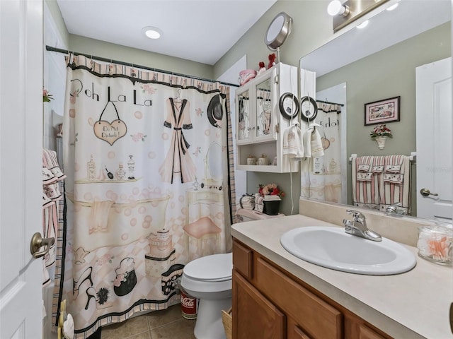 bathroom with curtained shower, vanity, tile patterned flooring, and toilet