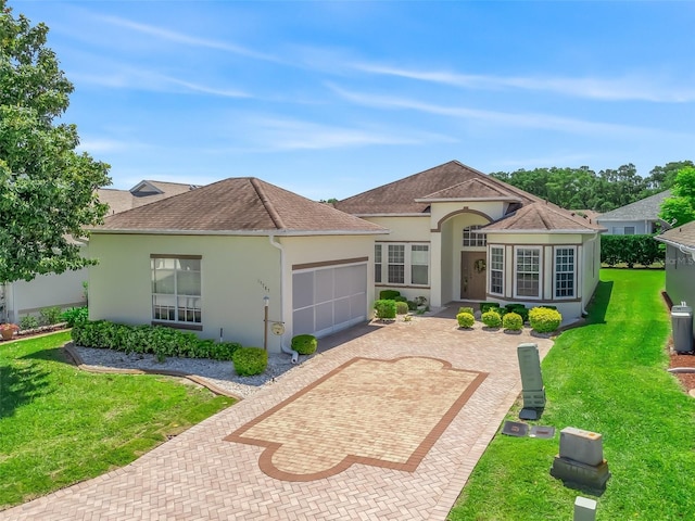 17787 SE 114th Ave, Summerfield, FL 34491 - view of front of house with a shingled roof, stucco siding, an attached garage, decorative driveway, and a front yard