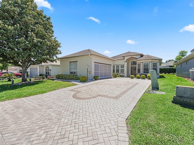17787 SE 114th Ave, Summerfield, FL 34491 - single story home with stucco siding, an attached garage, a front lawn, and decorative driveway