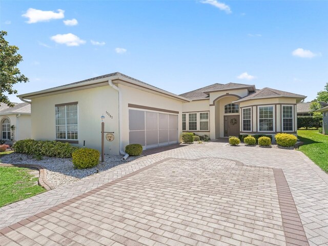 17787 SE 114th Ave, Summerfield, FL 34491 - view of front of house with stucco siding, an attached garage, and decorative driveway