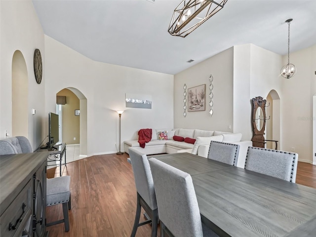 17787 SE 114th Ave, Summerfield, FL 34491 - dining area with baseboards, arched walkways, dark wood-type flooring, and an inviting chandelier