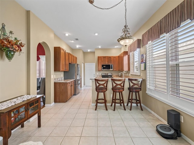 17787 SE 114th Ave, Summerfield, FL 34491 - kitchen featuring a kitchen breakfast bar, arched walkways, pendant lighting, a peninsula, and appliances with stainless steel finishes