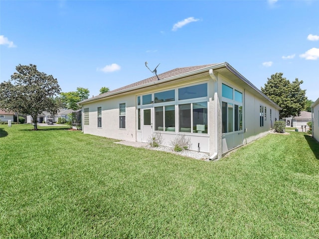17787 SE 114th Ave, Summerfield, FL 34491 - back of house with a lawn, a sunroom, and stucco siding