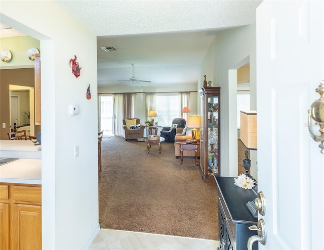 hall with visible vents and light carpet