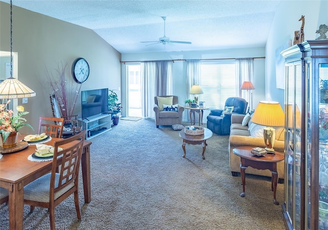 living area with carpet flooring, vaulted ceiling, a ceiling fan, and a textured ceiling