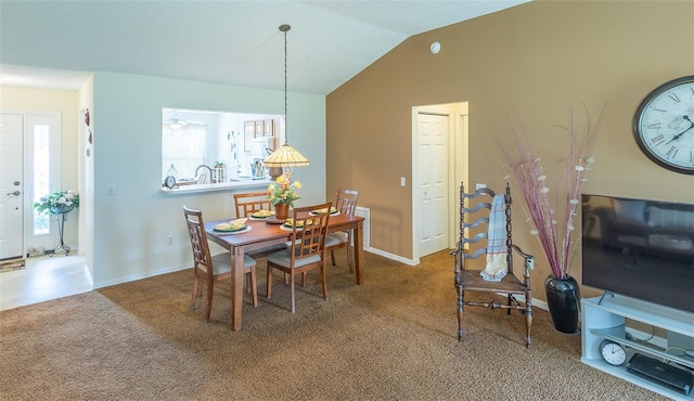 carpeted dining area with baseboards and vaulted ceiling
