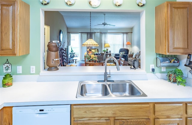 kitchen with open floor plan, light countertops, a ceiling fan, white dishwasher, and a sink