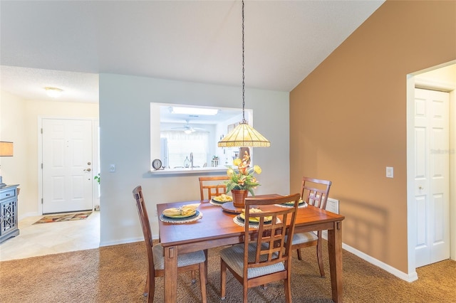 dining area with baseboards and light carpet