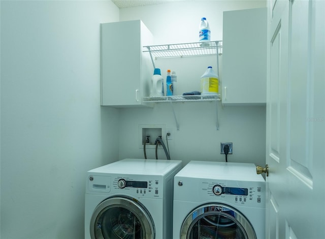 washroom featuring washing machine and clothes dryer and cabinet space