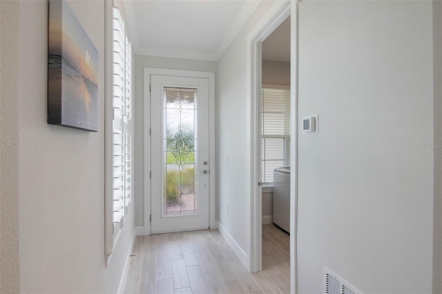 2129 Palm Tree Dr, Poinciana, FL 34759 - doorway to outside featuring light wood-type flooring, baseboards, and ornamental molding