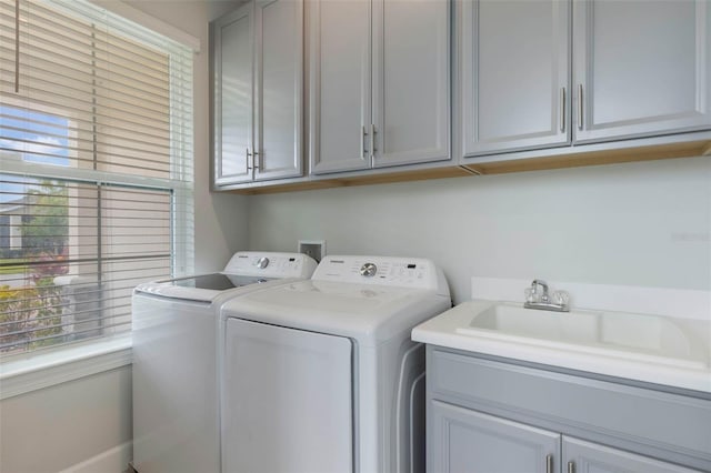 2129 Palm Tree Dr, Poinciana, FL 34759 - clothes washing area with washing machine and dryer, a healthy amount of sunlight, a sink, and cabinet space