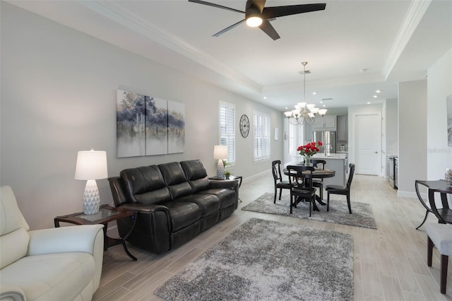 2129 Palm Tree Dr, Poinciana, FL 34759 - living room with crown molding, ceiling fan with notable chandelier, a tray ceiling, light wood finished floors, and recessed lighting