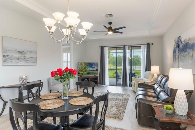 2129 Palm Tree Dr, Poinciana, FL 34759 - dining room featuring a raised ceiling, ceiling fan with notable chandelier, visible vents, and a healthy amount of sunlight