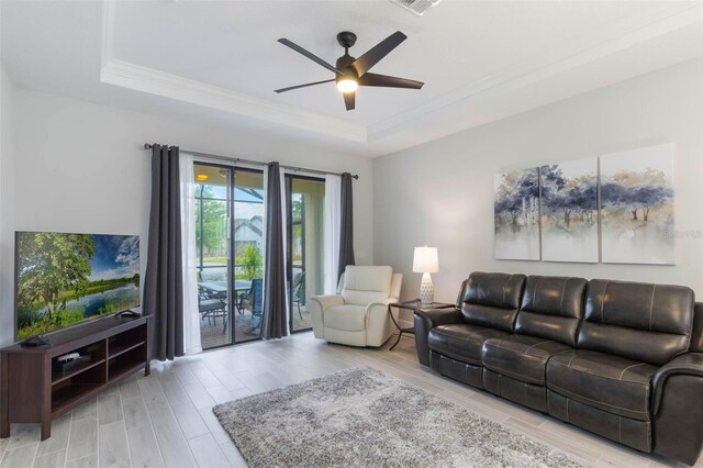 2129 Palm Tree Dr, Poinciana, FL 34759 - living area with a tray ceiling, visible vents, wood finished floors, ceiling fan, and crown molding