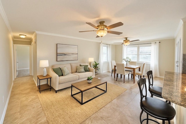 living room with crown molding, light tile patterned floors, baseboards, and a ceiling fan