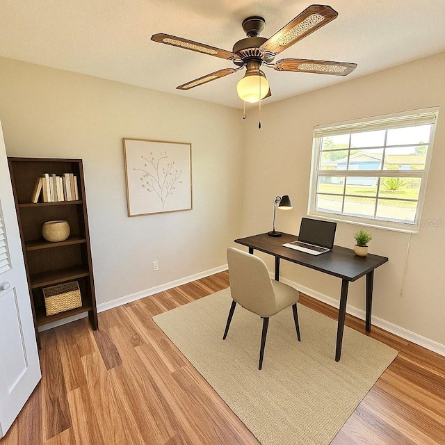office featuring light wood finished floors, baseboards, and a ceiling fan