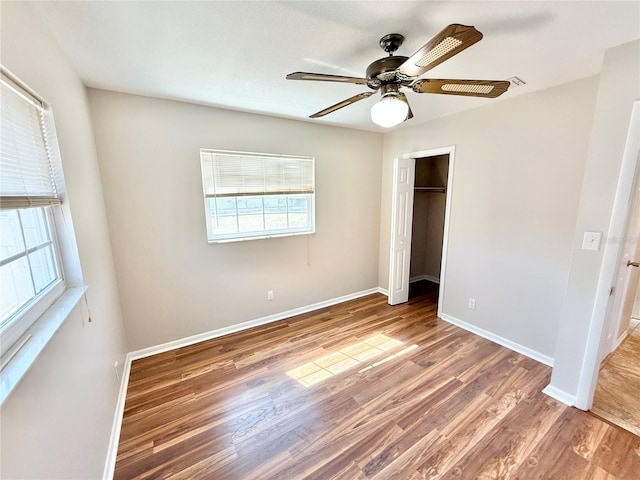 unfurnished bedroom featuring a ceiling fan, wood finished floors, baseboards, and a closet