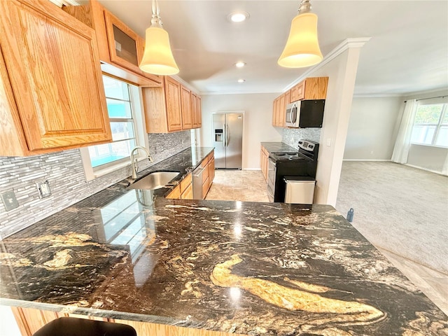 kitchen with crown molding, dark stone counters, decorative backsplash, stainless steel appliances, and a sink