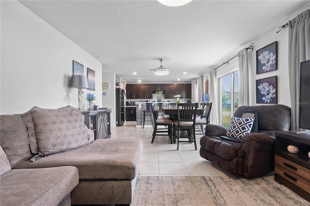 living area featuring light tile patterned floors, recessed lighting, and a textured ceiling
