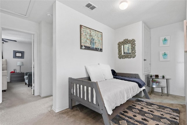 bedroom with baseboards, visible vents, a textured ceiling, and light colored carpet