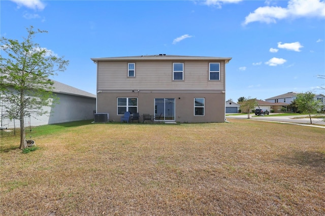 back of property featuring stucco siding, cooling unit, and a yard
