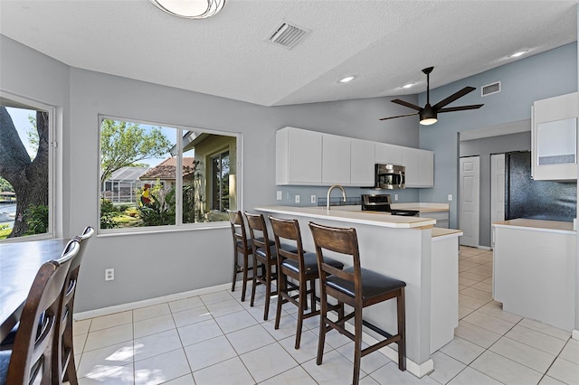 14 Clear Ct, Palm Coast, FL 32137 - kitchen with stainless steel appliances, visible vents, white cabinets, and light countertops