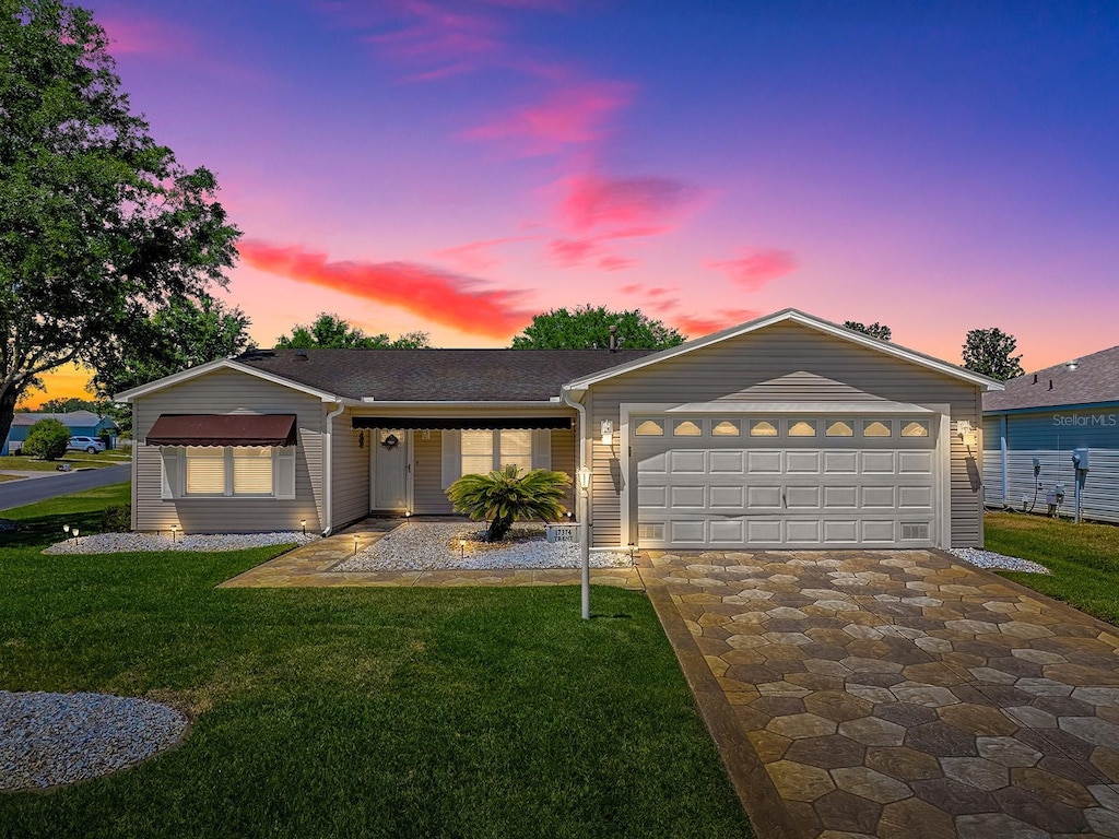 ranch-style home featuring driveway, a garage, and a front yard