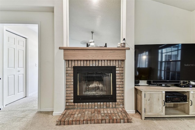 living area featuring a fireplace, baseboards, and carpet